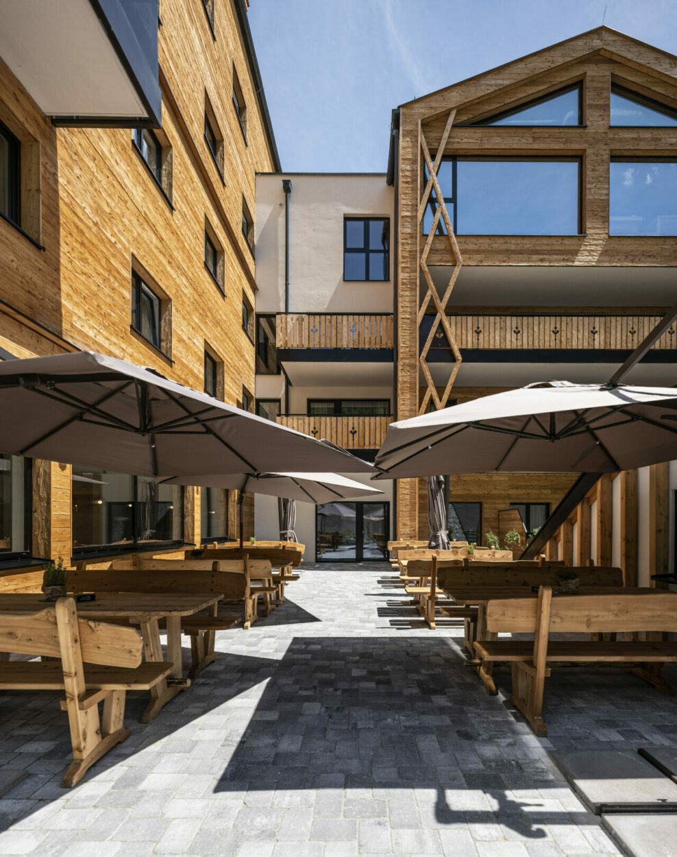 Hotel mit Außenbereich und Sitzgelegenheiten im Sommer.