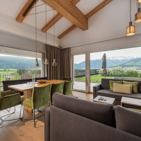 Innenansicht von Apartment im carpe Solem Hotel in Mariapfarr. Esstisch und Wohnzimmer in gemütlicher Holzausführung sowie hochwertige Polstermöbel für einen Urlaub im Salzburger Lungau.